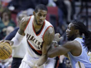 Portland Trail Blazers forward LaMarcus Aldridge, left, works the ball against Denver Nuggets forward Kenneth Faried during the first half of an NBA basketball game in Portland, Ore., Thursday, Jan. 23, 2014.