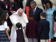 Pope Francis greets children as he is escorted by President Barack Obama after arriving at Andrews Air Force Base in Md., Tuesday, Sept. 22, 2015. The Pope is spending three days in Washington before heading to New York and Philadelphia. This is the Pope's first visit to the United States. First lady Michelle Obama, second from right, and Sasha Obama, right, watch.