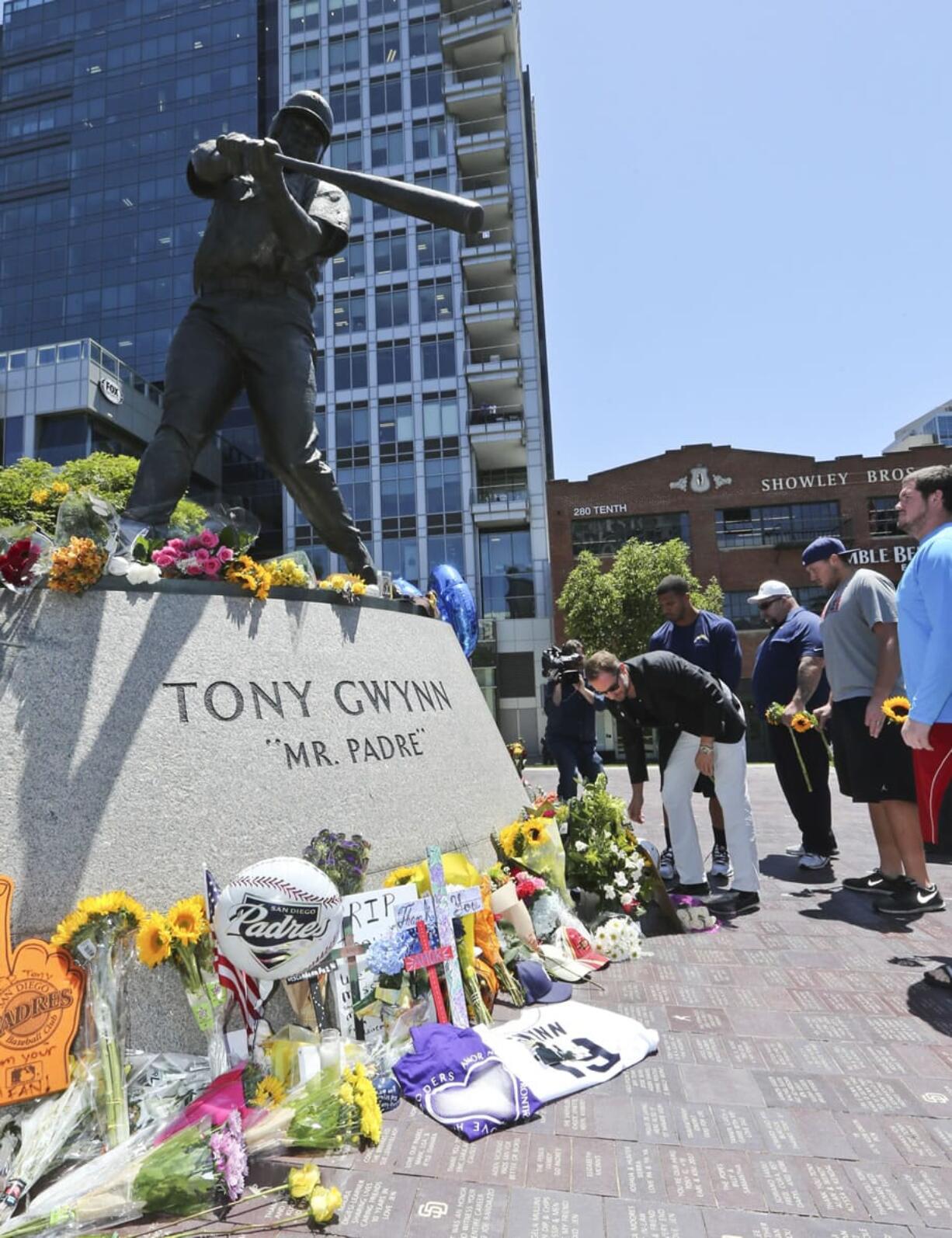 A.G. Spanos, CEO of the San Diego Chargers, leads his team as they place flowers and other mementos at the base of the Tony Gwynn &quot;Mr. Padre&quot; statue, Monday, June 16, 2014, in San Diego. Gwynn, an eight time National League batting champion with the San Diego Padres and a member of Baseball Hall of Fame, died Monday from cancer. He was 54.