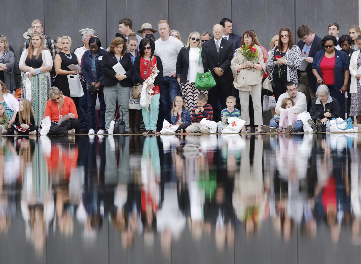 People watch from the edge of the reflecting pool in front of the 9:03 gate during a remembrance ceremony on Sunday at the Oklahoma City National Memorial