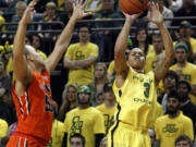 Oregon's Joseph Young, right, shoots a 3-point basket ahead of coverage by Oregon State's Roberto Nelson, left, during the first half at Eugene, Ore., on Sunday.