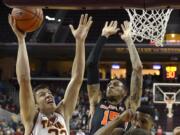 USC forward Nikola Jovanovic, left, puts up a shot as Oregon State forward Eric Moreland defends during the first half Thursday. (AP Photo/Mark J.