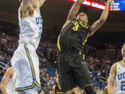 Oregon guard Joseph Young, right, goes up for a lay up against UCLA forward Travis Wear in the first half Thursday. (AP Photo/Ringo H.W.