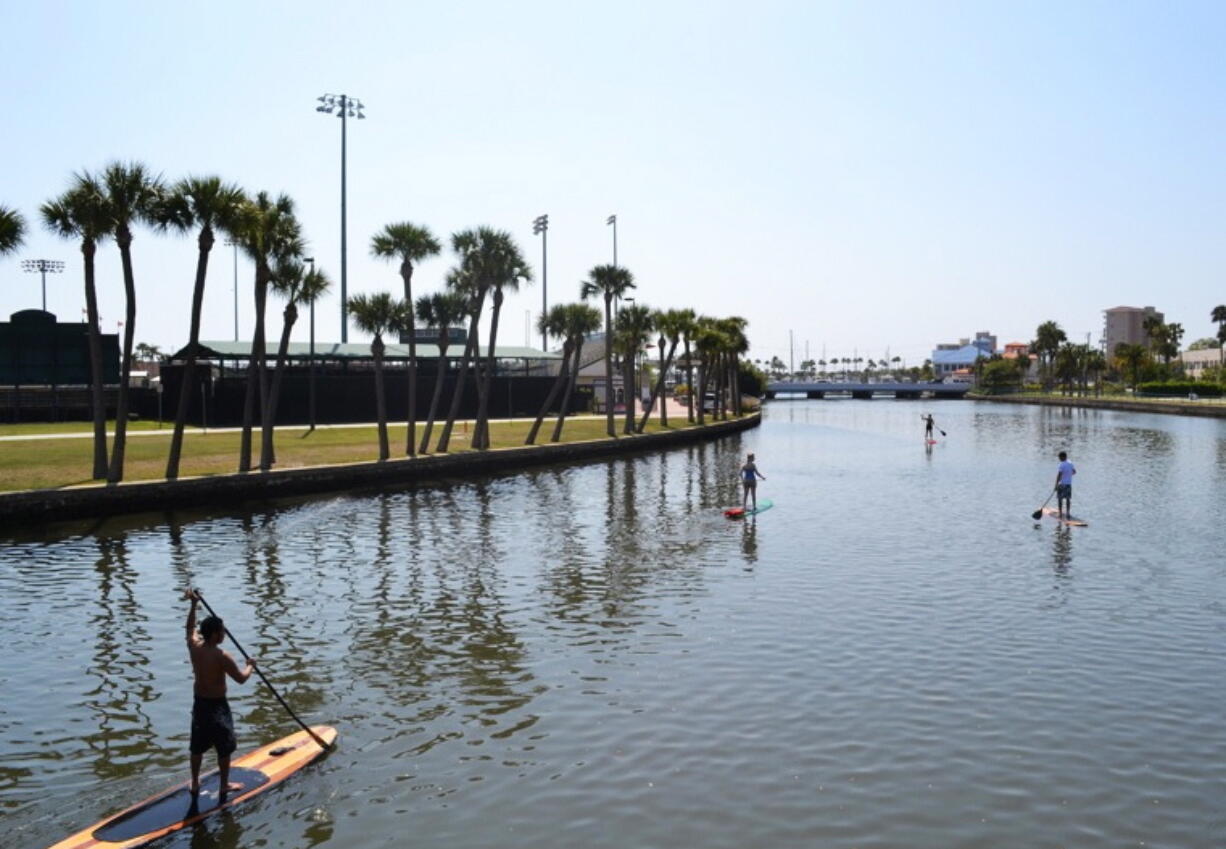 Austin Marvin and tour customers passing the Jackie Robinson Memorial Ball Park on the Halifax River, Daytona Beach, Fla. A sort of combination between surfing and kayaking, standup paddling has exploded in popularity the past few years.