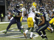 Seattle Seahawks running back Marshawn Lynch, left, looks back after a touchdown against the Green Bay Packers in the second half of an NFL football game, Thursday, Sept. 4, 2014, in Seattle.