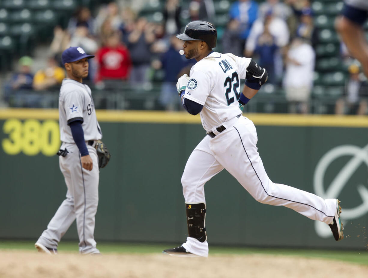 Seattle Mariners' Robinson Cano, right, blows a bubble as he rounds the bases after hitting a two-run home run during the fifth inning against the San Diego Padres in Seattle, Tuesday.