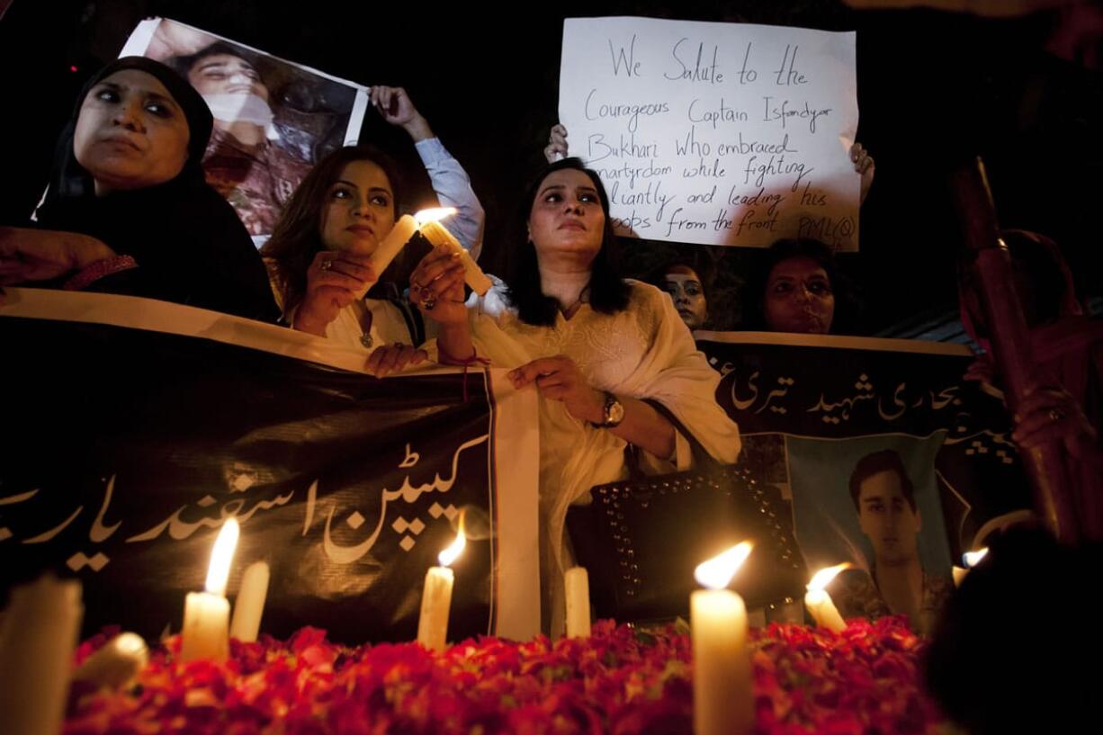 People light candles to pay tribute to soldiers who lost their lives during the Taliban attack, in Karachi, Pakistan, Frida. A brazen Taliban attack on a Pakistani military base on the outskirts of the northwestern city of Peshawar killed many people on Friday, including  worshippers who were gunned down when the militants stormed a mosque inside the compound during prayers.