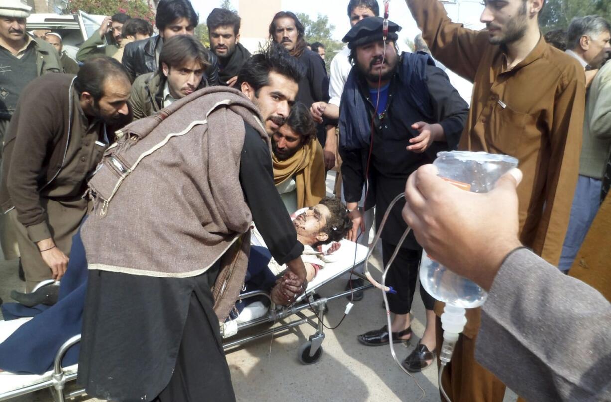 A Pakistani man, who was injured in a bomb blast, is rushed to a hospital in Kohat, Pakistan, Sunday, Feb. 23, 2014.  A bomb planted at a busy bus terminal near a police station in northwest Pakistan exploded Sunday killing several people and wounding many near the country's lawless tribal region, authorities said. The explosion targeted passengers in a motorized rickshaw and on a mini-bus in Kohat, some 150 kilometers (100 miles) west of the capital, Islamabad, police official Iqbal Khan said.