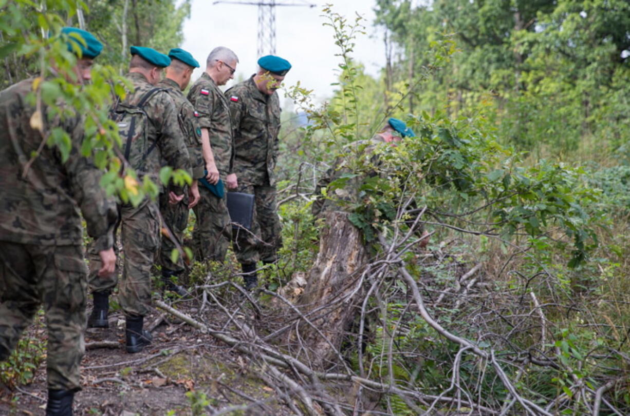 Polish military officials inspect the site where, according to two men, a World War II armored train is hidden in the ground, on Sept. 4 in Walbrzych, Poland.