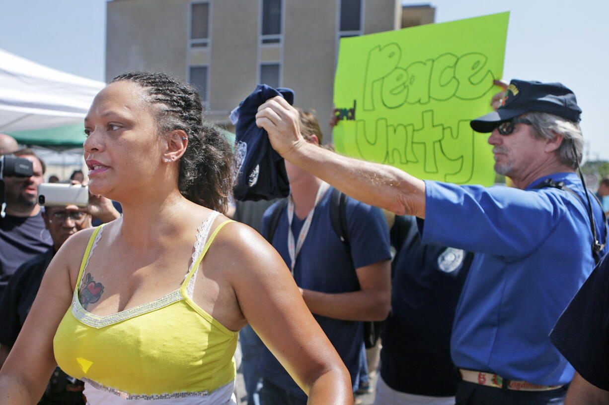 Sondra Fifer, of St. Louis, voices her disagreement with the rally for Ferguson police Officer Darren Wilson on Saturday, Aug. 23, 2014, at Barney's Sports Pub in St. Louis. &quot;I'm not against officers, I'm against police brutality,&quot; Fifer said. Ferguson's streets remained peaceful as tensions between police and protesters continued to subside after nights of violence and unrest that erupted when Wilson, a white police officer, fatally shot Michael Brown, an unarmed black 18-year-old. (AP Photo/St.