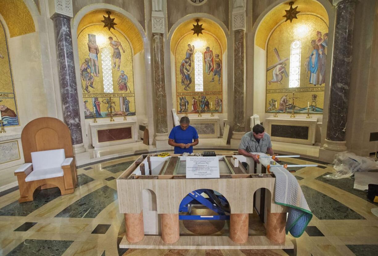 Deacon David Cahoon, right, from the Archdiocese of Washington and professional carpenter, and head carpenter Carlos Hernandez, left, continue to work on the altar that Pope Francis will use during his Mass next week, inside the Basilica of the National Shrine of the Immaculate Conception in Washington on Thursday.