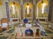 Deacon David Cahoon, right, from the Archdiocese of Washington and professional carpenter, and head carpenter Carlos Hernandez, left, continue to work on the altar that Pope Francis will use during his Mass next week, inside the Basilica of the National Shrine of the Immaculate Conception in Washington on Thursday.