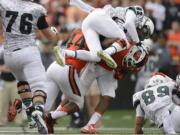 Portland State receiver Darnell Adams (82) is tackled by Oregon State safety Justin Strong during an NCAA college football game in Corvallis, Ore., Saturday, Aug. 30, 2014.