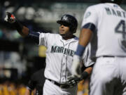 Seattle Mariners' Nelson Cruz reacts as he reaches home plate after hitting a two-run home run that also scored Ketel Marte (4) in the seventh inning of a baseball game against the Texas Rangers, Thursday, Sept. 10, 2015, in Seattle. The Mariners won 5-0. (AP Photo/Ted S.