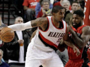 Portland Trail Blazers forward LaMarcus Aldridge, left, maneuvers against Toronto Raptors forward Amir Johnson during the first half of an NBA basketball game in Portland, Ore., Tuesday, Dec. 30, 2014.