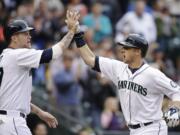 Seattle Mariners' Justin Smoak, right, is congratulated by Corey Hart as he crosses home on his two-run home run against the Kansas City Royals in the fourth inning Saturday.