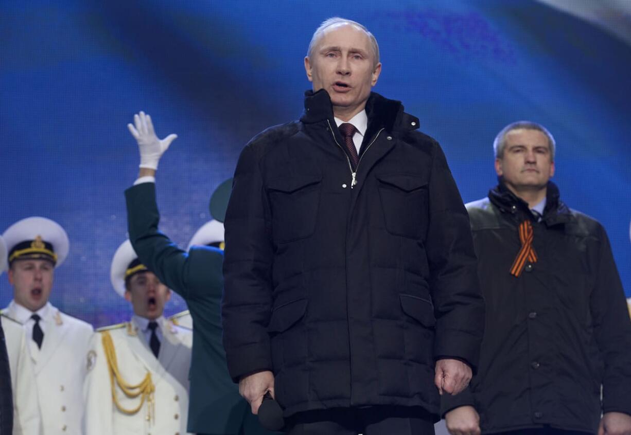 Russian President Vladimir Putin sings the national anthem at a rally in support of Crimea joining Russia in Red Square in Moscow on Tuesday.