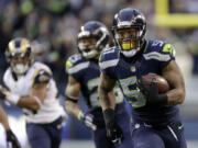 Seattle Seahawks linebacker Bruce Irvin, right, returns an interception for a touchdown against the St. Louis Rams in the fourth quarter Sunday, Dec. 28, 2014, in Seattle.