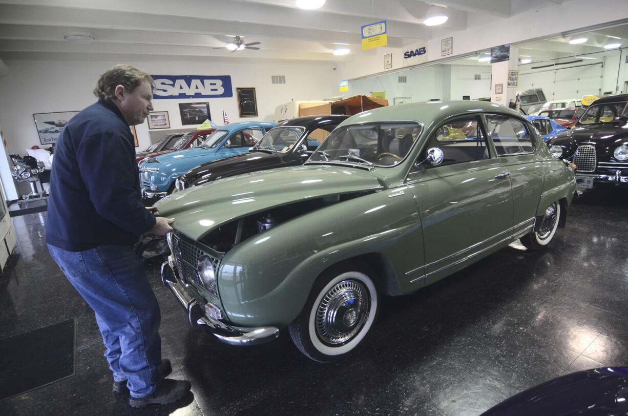 Tom Donney pops the trunk of his Saab Monte Carlo in his showroom, in Fort Dodge, Iowa.