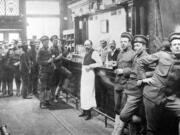 Military men from the Vancouver Barracks belly up to the bar at the downtown Log Cabin Saloon on Sixth Street, a popular drinking hole for soldiers.