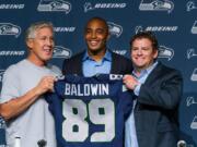 Seahawks Seahawks coach Pete Carroll, left, wide receiver Doug Baldwin, center, and general manager John Schneider for a photo with Baldwin's jersey at a news conference in Renton, Wash., on Thursday, May 29, 2014. Baldwin signed an extension that will keep him with the Seahawks through the 2016 season.