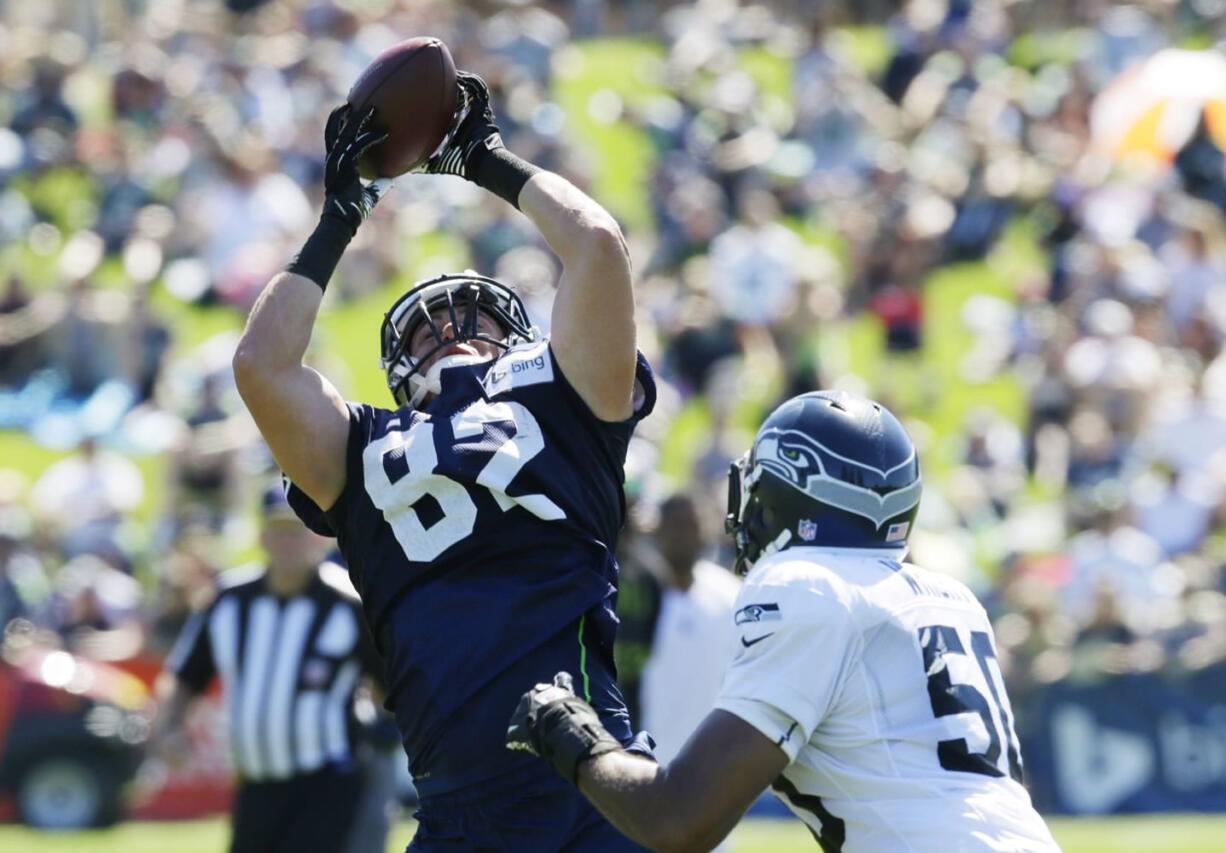 Seattle Seahawks' tight end Luke Willson, left, makes a catch as outside linebacker K.J. Wright, right, defends, during NFL football training camp, Thursday, July 31, 2014, in Renton, Wash. (AP Photo/Ted S.