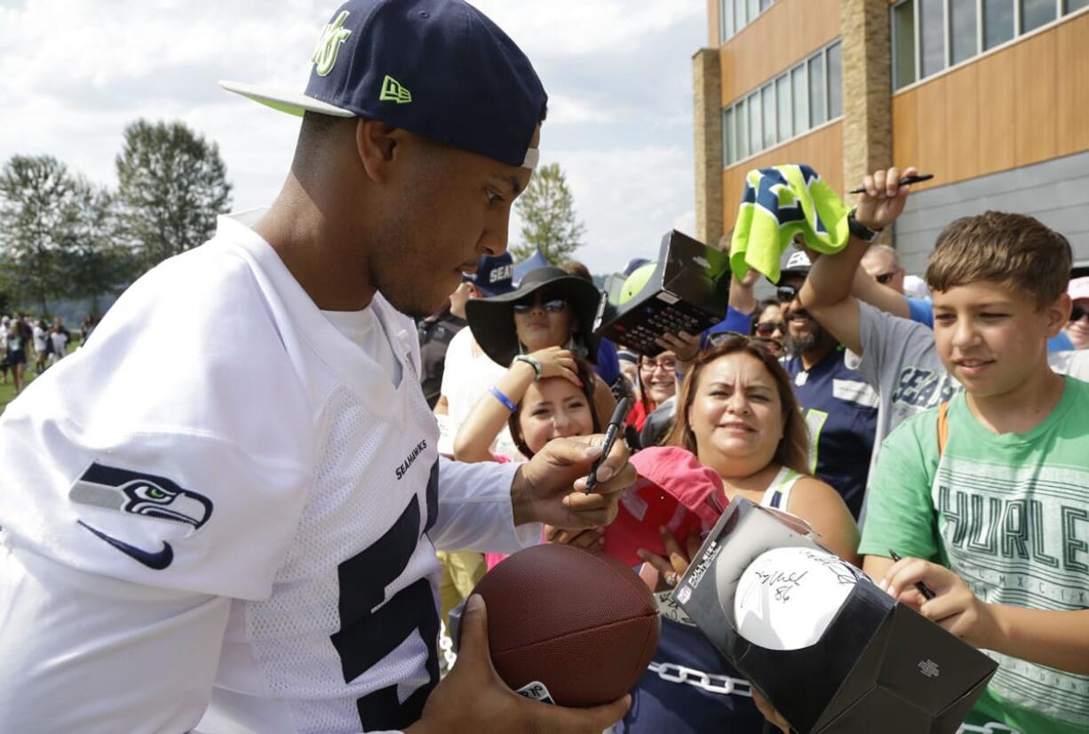 Seattle Seahawks outside linebacker Malcolm Smith signs autographs Aug. 2 after a training camp in Renton. The Super Bowl MVP had his first on-field practice Tuesday.