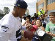 Seattle Seahawks outside linebacker Malcolm Smith signs autographs Aug. 2 after a training camp in Renton. The Super Bowl MVP had his first on-field practice Tuesday.