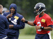 Seattle Seahawks quarterback Russell Wilson, right, greets running back Marshawn Lynch at a football minicamp practice Tuesday in Renton.