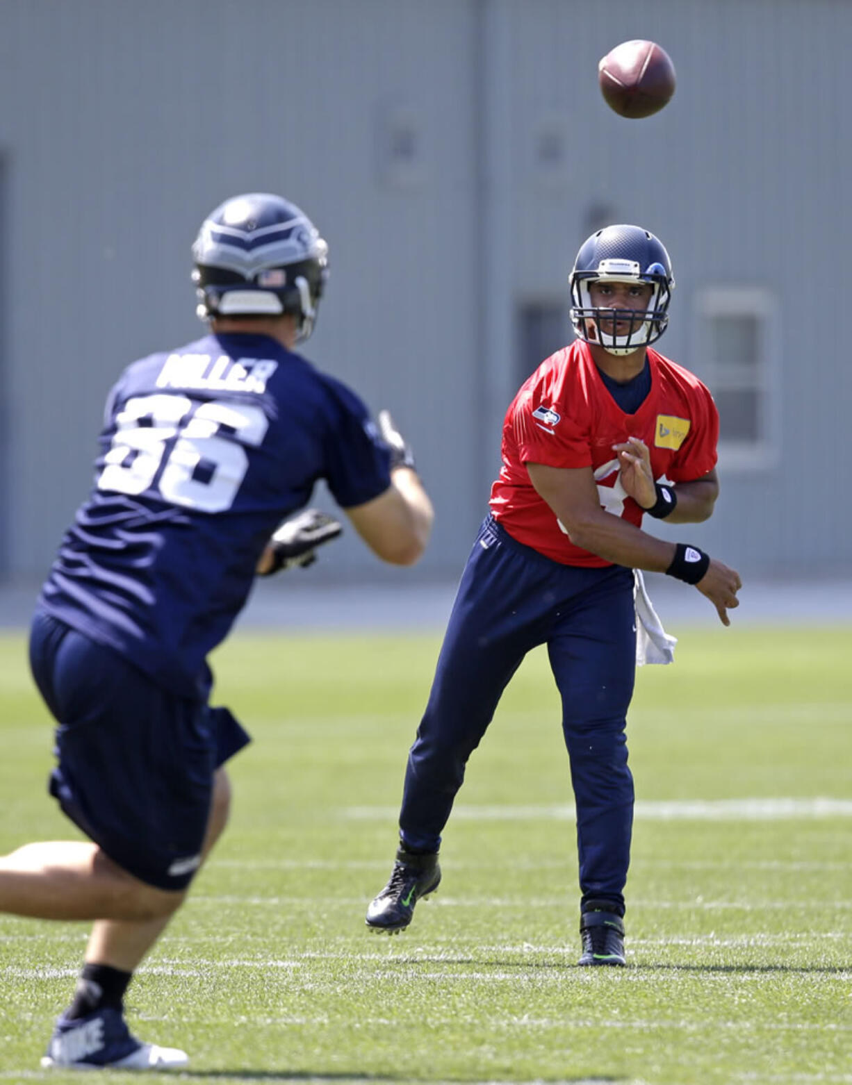 Seattle Seahawks quarterback Russell Wilson, right, passes to Zach Miller at Monday's practice session in Renton, Wash.