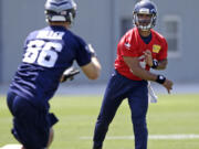 Seattle Seahawks quarterback Russell Wilson, right, passes to Zach Miller at Monday's practice session in Renton, Wash.