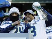 Seattle Seahawks quarterback Russell Wilson, right, lifts the Vince Lombardi Trophy next to Seahawks running back Marshawn Lynch, left, during a rally on Feb. 5.