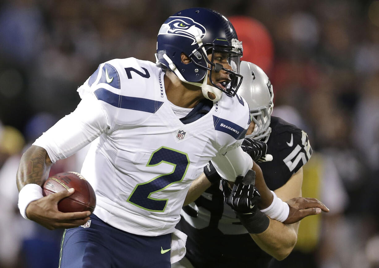 Seattle Seahawks quarterback Terrelle Pryor (2) runs against Oakland Raiders linebacker Miles Burris during the second quarter of an NFL preseason football game in Oakland, Calif., Thursday, Aug. 28, 2014.