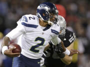 Seattle Seahawks quarterback Terrelle Pryor (2) runs against Oakland Raiders linebacker Miles Burris during the second quarter of an NFL preseason football game in Oakland, Calif., Thursday, Aug. 28, 2014.