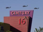 Three helicopters make a flyover of the Century Theater in Aurora, Colo., July 21, 2012, a day after 12 people were killed and dozens were injured in a shooting at &quot;The Dark Knight Rises.&quot; The theater is still fighting 20 lawsuits that claim it should have provided better security.