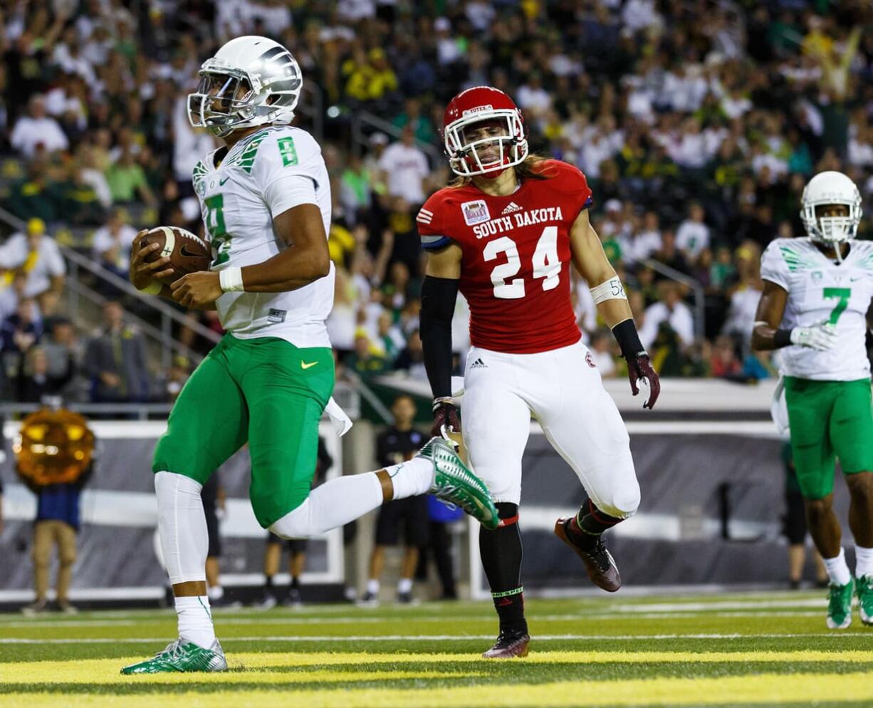 Oregon quarterback Marcus Mariota (8) runs into the end zone for a touchdown during the second quarter of an NCAA college football game against South Dakota in Eugene, Ore., Saturday, Aug. 30, 2014.