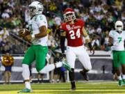 Oregon quarterback Marcus Mariota (8) runs into the end zone for a touchdown during the second quarter of an NCAA college football game against South Dakota in Eugene, Ore., Saturday, Aug. 30, 2014.