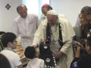 Pope Francis blesses to a disabled child during his visit to the rehabilitation center for disabled people at Kkottongnae in Eumseong, South Korea, on Saturday.