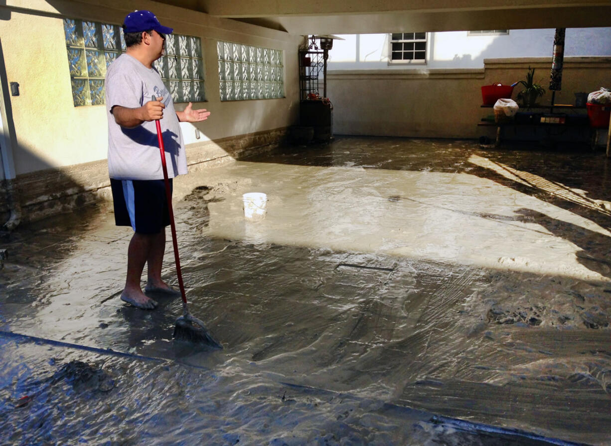 Hector Brown sweeps out his aunt and uncle's house in Seal Beach, Calif., on Wednesday.