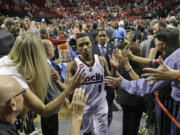 Portland Trail Blazers' Damian Lillard (0) walks off the court as fans reach for him following Game 4 of a Western Conference semifinal NBA basketball playoff series against the San Antonio Spurs, Monday, May 12, 2014, in Portland, Ore. The Trail Blazers won 103-92.