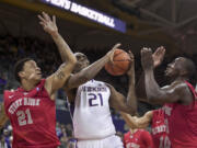 Washington's Jernard Jarreau, center, vies for a rebound with Stony Brook's Rayshaun McGrew, left, and Jameel Warney during the first half Sunday, Dec. 28, 2014, in Seattle.