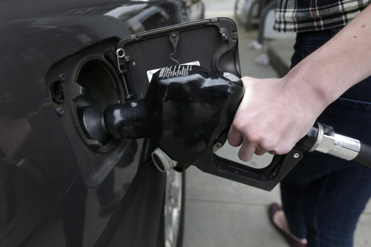 A customer fills her car at a gas station in Brookline, Mass.