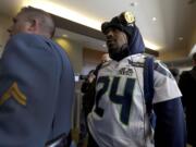 A member of the New Jersey state police escorts Seattle Seahawks running back Marshawn Lynch, right, through an area where a media availability was being held at the team's hotel Wednesday, Jan. 29, 2014, in Jersey City, N.J. The Seahawks and the Denver Broncos are scheduled to play in the Super Bowl XLVIII football game Sunday, Feb. 2, 2014.