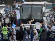 A huge crowd in SeaTac gives a rousing send-off to the Seattle Seahawks while the team buses go by on the way to the Sea-Tac International Airport.