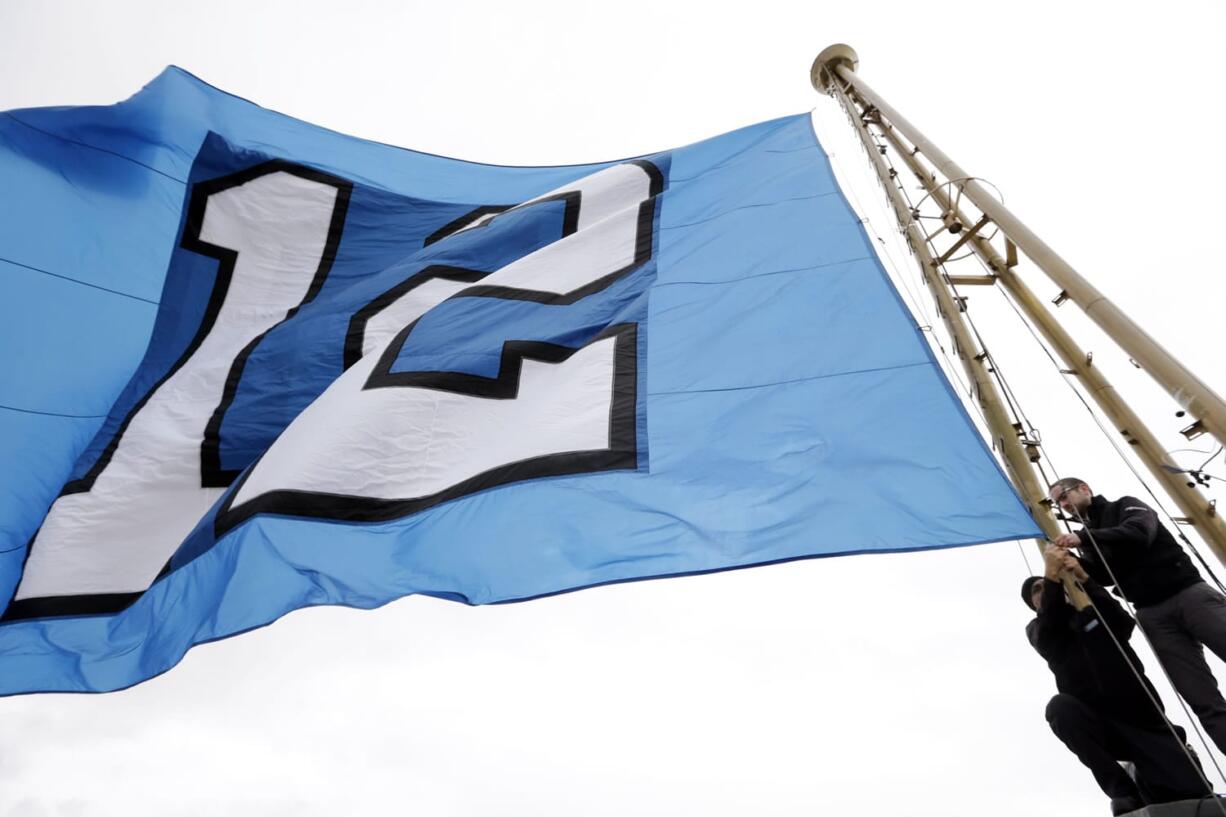 Workers re-set the &quot;12th Man&quot; flag, honoring Seattle Seahawks fans, after it was raised atop the Space Needle on Wednesday in Seattle.