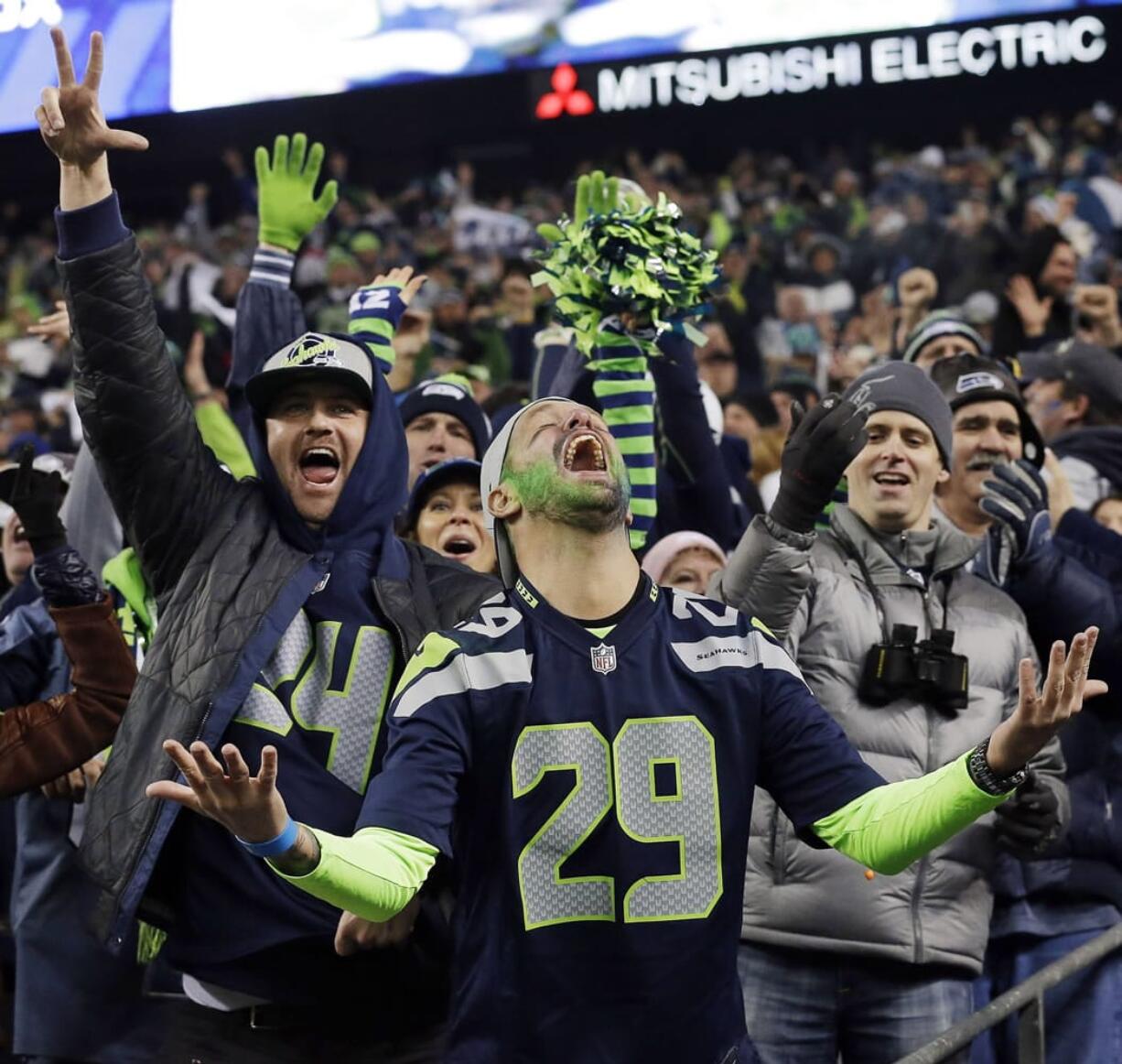 Seattle Seahawks fans celebrate a Seahawks touchdown run by Marshawn Lynch during the second half of the NFC championship game last Sunday.