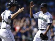 Seattle Mariners starting pitcher Roenis Elias, right, is greeted by catcher Mike Zunino after throwing a complete shutout baseball game against the Detroit Tigers, Sunday, June 1, 2014, in Seattle. The Mariners won 4-0. (AP Photo/Ted S.