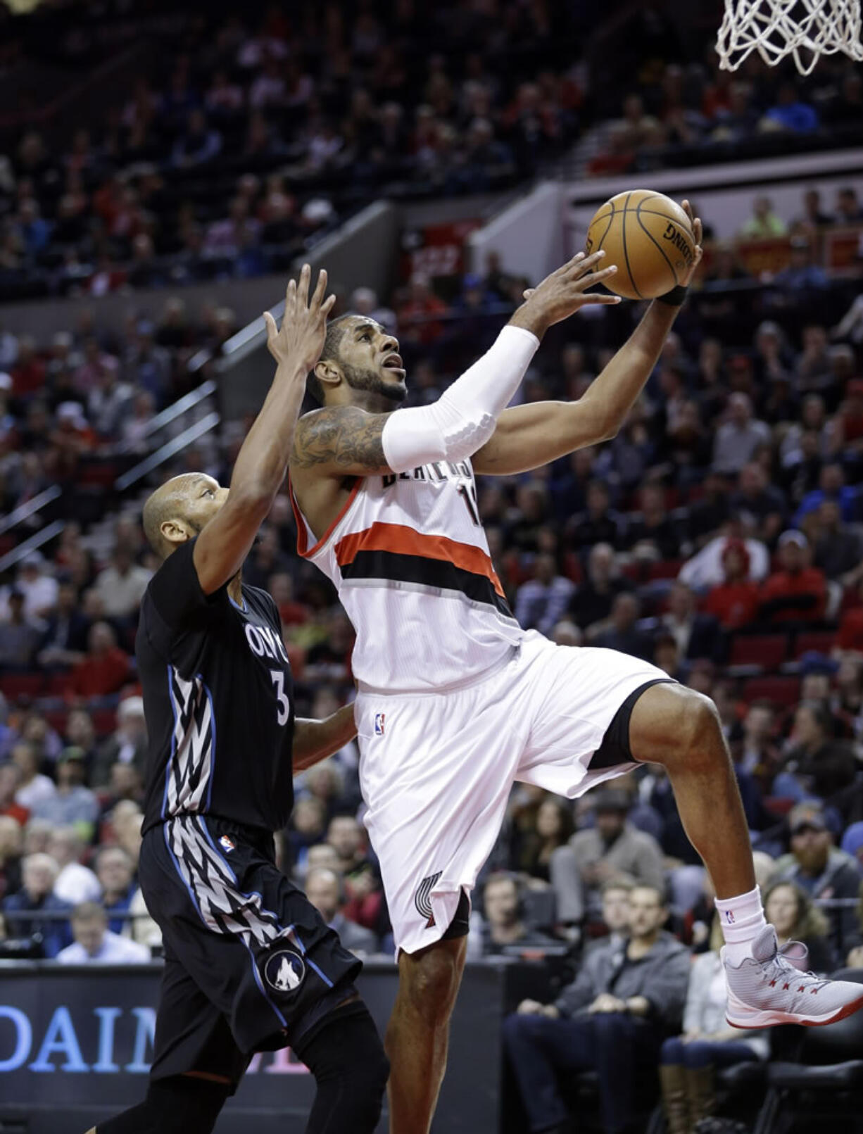 Portland Trail Blazers forward LaMarcus Aldridge, right, drives to the basket past Minnesota Timberwolves forward Adreian Payne during the first half Wednesday, April 8, 2015.