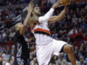 Portland Trail Blazers forward LaMarcus Aldridge, right, drives to the basket past Minnesota Timberwolves forward Adreian Payne during the first half Wednesday, April 8, 2015.