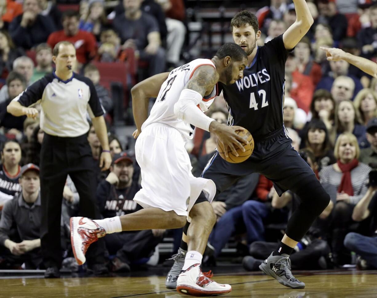 Portland Trail Blazers forward LaMarcus Aldridge, left, drives on Minnesota Timberwolves forward Kevin Love during the first half Saturday.